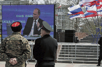 BBVA-OpenMind-Europa-Rusia y Europa-Orlando Figes-Cosacos en Sinferopol, capital de la República de Crimea, miranen la pantalla de televisión a Vladímir Putin en abril de 2015.