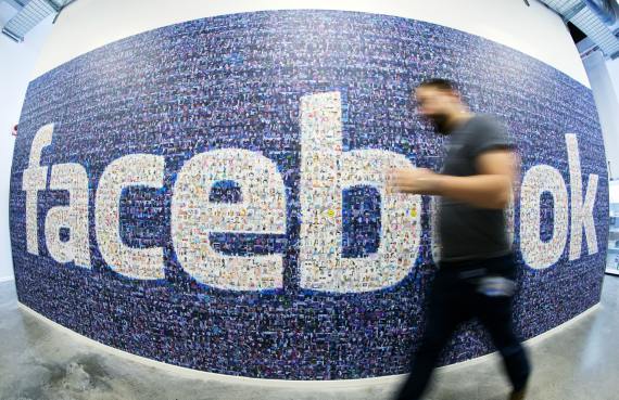 BBVA-OpenMind-Libro 2018-Perplejidad-Qureshi-facebook-A man walks past a wall sized logo created from pictures of Facebook users in the company's Data Center in Swedish Lapland. Facebook continues to enjoy remarkable success and is expanding into new areas such as artificial intelligence-Advanced Tech but Growth Slow and Unequal
