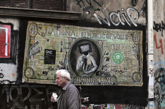BBVA-OpenMind-Ilustracion-Barry-Eichengreen-Ultima-decada-y-futuro-economia-global_A man walking past graffiti in central Athens on February 4, 2015, following elections won by the Radical Left Coalition (Syriza) led by Alexis Tsipras