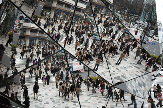 El paso de los transeúntes se refleja en la fachada de un centro comercial de la zona de compras de Omotesando, Tokio, marzo de 2013