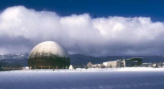 BBVA-OpenMind-ilustración-SANCHEZ-RON-Cuando-el-pasado-se-hace-futuro_la-fisica-siglo-xxi-Centro de exposiciones del CERN, en Suiza, en un día nevado. El edificio, construido en madera, lo donó al CERN la Confederación Suiza en 2004 para celebrar los 50 años de su fundación