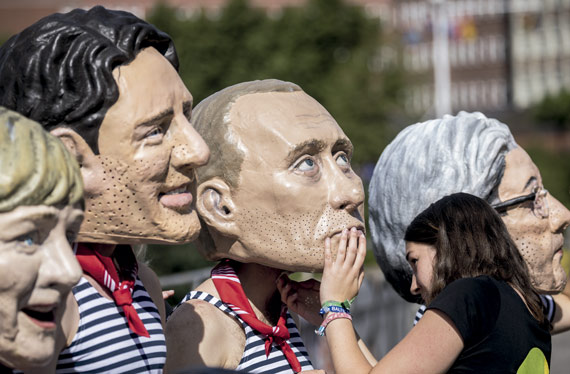 BBVA-OpenMind-ilustración-gonzalez-nueva-ilustracion-digital_papel-industria-financiera_Oxfam activists wearing masks with the faces of political leaders (in the photo: Vladimir Putin and former Italian prime minister Paolo Gentiloni) demonstrate at a G20 meeting in Hamburg, Germany, in July 2017