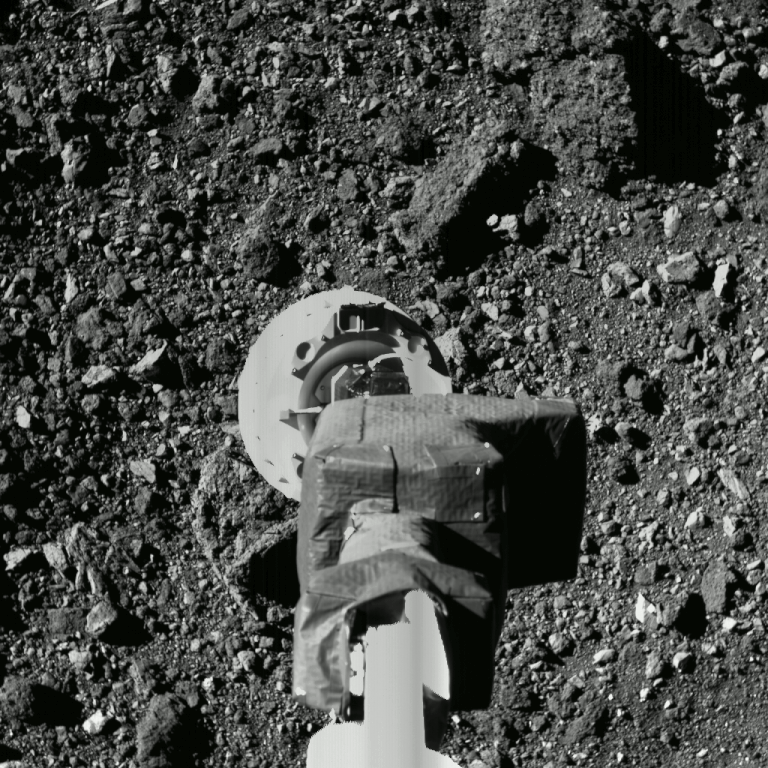 Prueba de aproximación a superficie de OSIRIS-REx, que muestra el brazo robótico TAGSAM encargado de aspirar las rocas y polvo. Crédito: NASA.